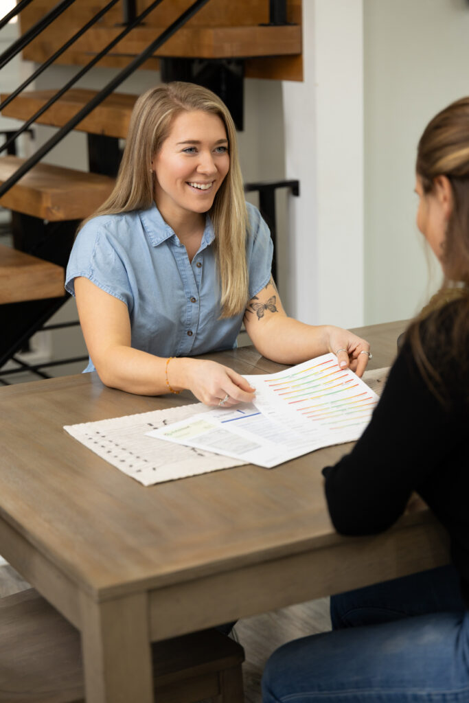 Two women sitting at a kitchen table going over test results showcasing a brand during a shoot.