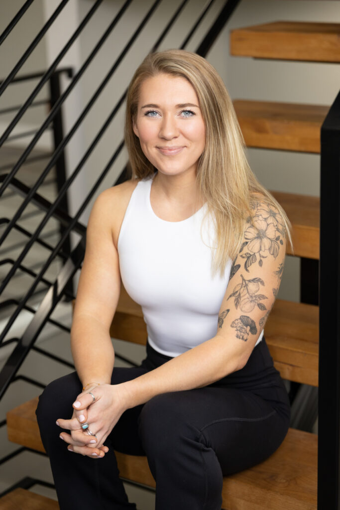 Woman sitting on stairs posing for the camera during a brand photography session with Sara Vaz in Utah.