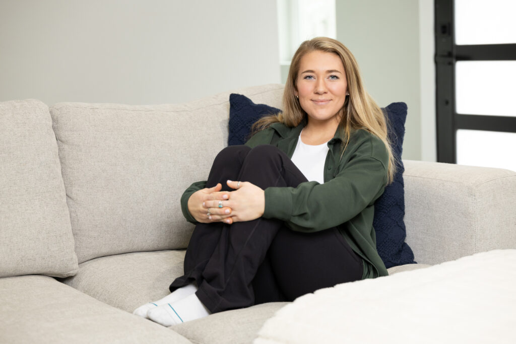 Portrait of woman sitting on couch in comfy clothes during a personal brand photo shoot in Utah.