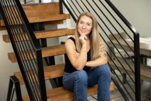 Woman sitting on stairs with holding chin for portrait in Utah.