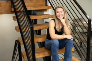 Woman sitting in staircase for portrait during brand session in Utah.
