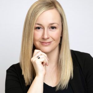 Headshot of woman posing for branding photos by Sara Vaz Photography on a white background in a Utah studio.